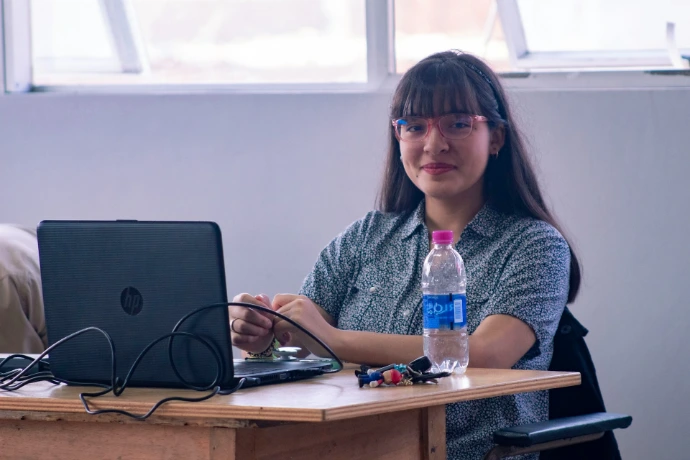 A woman sitting at a desk with a laptop computer